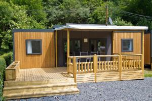 eine Holzhütte mit einer Terrasse und einer Veranda in der Unterkunft Tornade in Dirbach