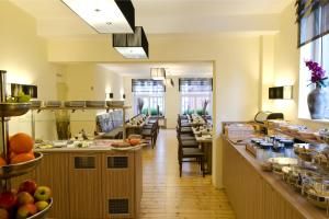 a restaurant with a buffet line with tables and chairs at Hotel Die Tanne in Goslar