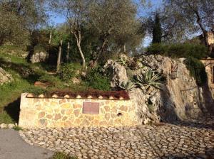 a stone wall with a plaque on top of it at Valuable rustic Tuscan swimming pool, breathtaking view of Camaiore in Camaiore