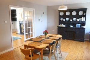a dining room with a wooden table and chairs at Rosaries Apartment Kilkee in Kilkee