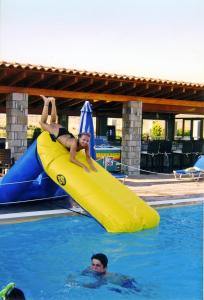 a woman riding on top of a raft in a swimming pool at Evgatis Hotel in Kondiás