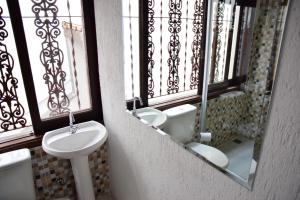 a bathroom with a sink and a toilet and a mirror at Hotel Alvorada do Sol in Sao Paulo