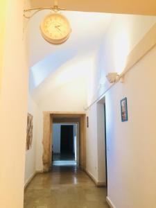 a hallway with a clock on the wall at Ostello della Gioventù - Il Castello in Noto