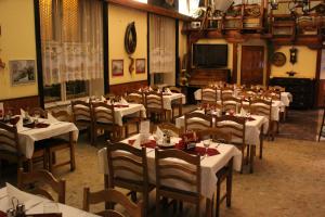 comedor con mesas y sillas blancas y TV en Hotel Max Šimek, en Ostrava