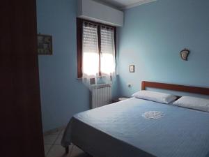 マルティンシクーロにあるAppartamenti Mimosaの青いベッドルーム(ベッド1台、窓付)