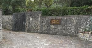 een stenen muur met een hek en een bord erop bij Il Poggio del Cilento Country House in Agropoli