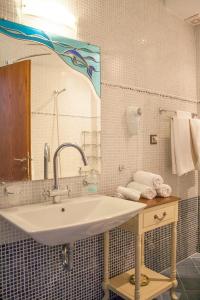 a bathroom with a sink and a mirror and towels at Villa Fotini in Skiathos