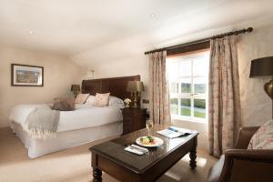 a bedroom with a bed and a table and a couch at Bushmills Inn Hotel & Restaurant in Bushmills +37 photos