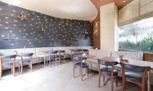 a restaurant with wooden tables and blue chairs at Treebo Trend Olive Nest in Mumbai