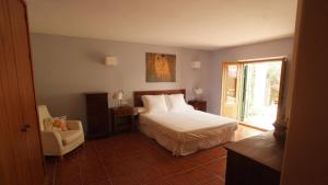 ニハルにあるCasa El Arenalのベッドと椅子と窓のある寝室 +36枚の写真