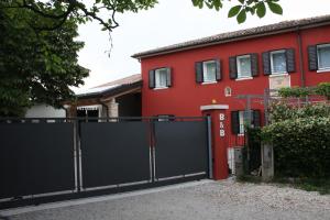 een zwarte poort voor een rood huis bij B&B Alla Bon'ora in Volpago del Montello +13 foto's