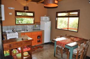 a kitchen with a table and a white refrigerator at Cabañas La Pampilla in San Javier