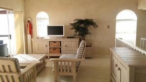 uma sala de estar com uma televisão num armário em The Beach Villa em Melkbosstrand