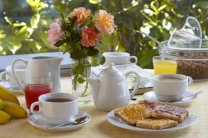 サレルノにあるLe ginestre di Titina - casa vacanzaのコーヒー、トースト、花の朝食付きテーブル