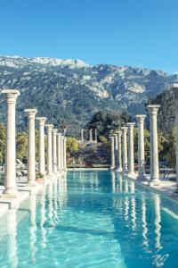 a swimming pool with columns and blue water at Finca Cas Sant in Sóller