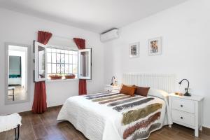 アルビールにあるLa Casita del Albirの白いベッドルーム(ベッド1台、窓付)