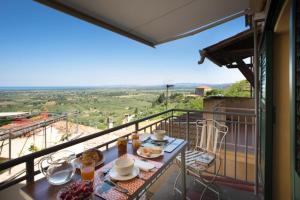 einen Tisch mit Speisen auf einem Balkon mit Aussicht in der Unterkunft NinnaNannaMare-suite apartment in Castagneto Carducci
