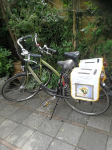 een fiets geparkeerd met een witte tas op de achterkant bij Maizon Middelburg in Middelburg