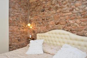 a brick wall with a bed with two pillows at Residence Cà di Capri in Bussolengo