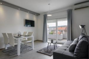 een woonkamer met een bank en een tafel bij Villa Apartment AA 2 in Trogir