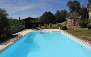 a large blue swimming pool in front of a house at Chambre d'Hotes C de C in Sauliac-sur-Célé