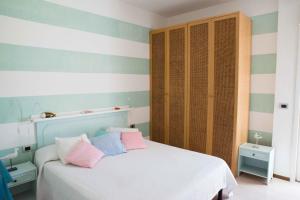 een slaapkamer met een bed met roze en blauwe strepen bij Acquamarina in Alba Adriatica
