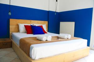 een slaapkamer met een groot bed met blauwe muren bij Deodonum Luxury Apartments in Heraklion
