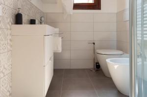 a white bathroom with a toilet and a sink at BRE Apartments - Fresche Frasche in Vicenza +13 photos
