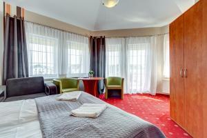 a hotel room with a bed and chairs and windows at Villa Melody in Rewal +42 photos