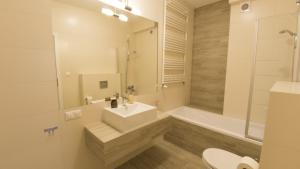 Un baño con lavabo, inodoro y bañera. en Apartament Termalny Komfort 8.1, en Uniejów