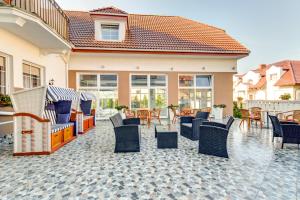 a patio with chairs and tables and a building at Villa Melody in Rewal