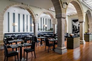 een restaurant met tafels en stoelen in een kamer bij Eurostars Asta Regia Jerez in Jerez de la Frontera