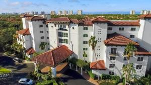 an aerial view of a large white building with red roofs at Inn at Pelican Bay in Naples