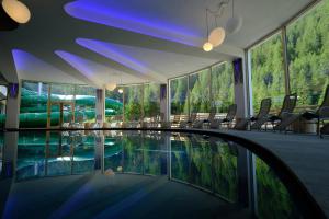 a swimming pool in a hotel with a mountain view at Vidor Resort in Pozza di Fassa