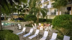 a patio with chairs and a table and a building at Inn at Pelican Bay in Naples