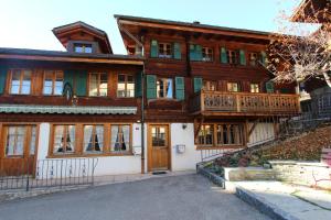 a large wooden house with a balcony at Tambour 4 in Rossinière