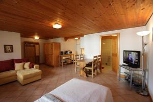 a living room with a couch and a table with a television at Tambour 4 in Rossinière