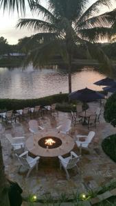 a patio with chairs and a fire pit in front of a lake at Inn at Pelican Bay in Naples