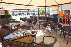 an empty restaurant with tables and chairs and a playground at Complex Moskoyani in Nesebar