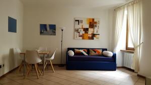 a living room with a blue couch and a table at Casa Francesca in Riva del Garda