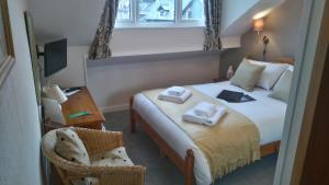 a bedroom with a bed with towels on it at Harvington House in Keswick