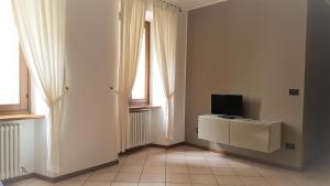 a living room with a tv and two windows at Casa Francesca in Riva del Garda