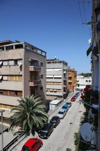 a city street with parked cars and buildings at Apartman Lana in city centre with garage in Zadar