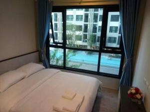 ein Schlafzimmer mit einem Bett und einem großen Fenster in der Unterkunft The Base Central in Pattaya + 19 Fotos