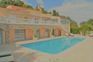 a house with a swimming pool in front of it at Villa La Terre Des Lauriers in Vallauris