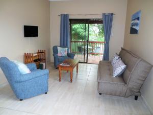 sala de estar con 2 sillas y TV en 102 Siyayi, en Mtunzini