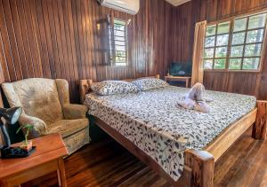 a bedroom with a bed and a chair at Cabinas Arrecife in Cahuita
