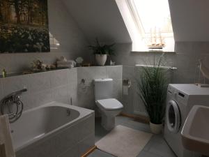 a bathroom with a tub and a toilet and a sink at Ferienwohnung zur Himmelsscheibe in Ziegelroda