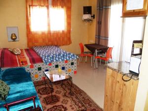 a living room with a bed and a table at Dar El Amen Appartements in Mahdia