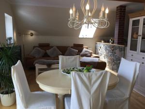 Ziegelroda的住宿－Ferienwohnung zur Himmelsscheibe，客厅配有桌子和白色椅子
